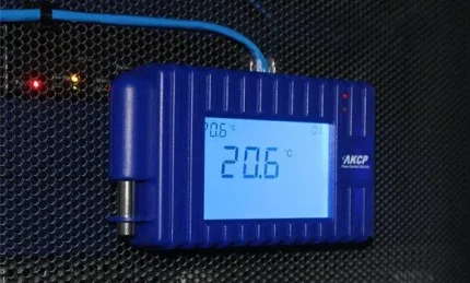 Afficheur LCD AKCP fixé sur une porte de baie affichant 20,6 degrés