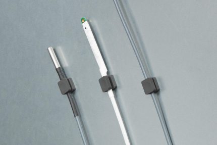 Trois clips magnétiques HWgroup fixant des sondes sur une tôle métallique grise